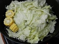 鍋裡先加2000c.c.的水，先放高麗菜與玉米煮