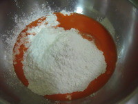 將糯米粉,在來米粉,糖,油放入盆中,胡蘿蔔汁倒入盆中一角。